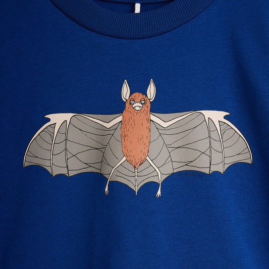 A close-up of a royal blue crewneck t-shirt featuring a cartoon graphic of a brown bat with gray wings on the chest.