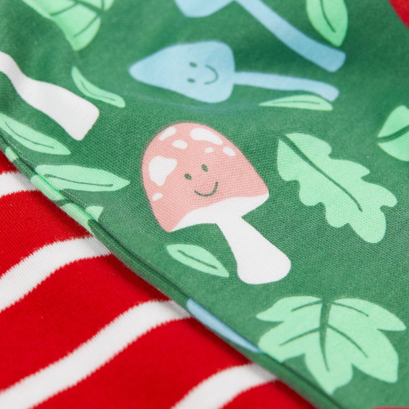 Close-up of fabric with mushroom and leaf pattern on green background