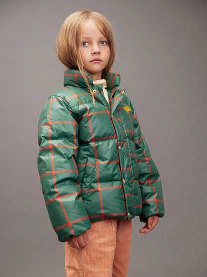 Child wearing a green plaid jacket on a gray background