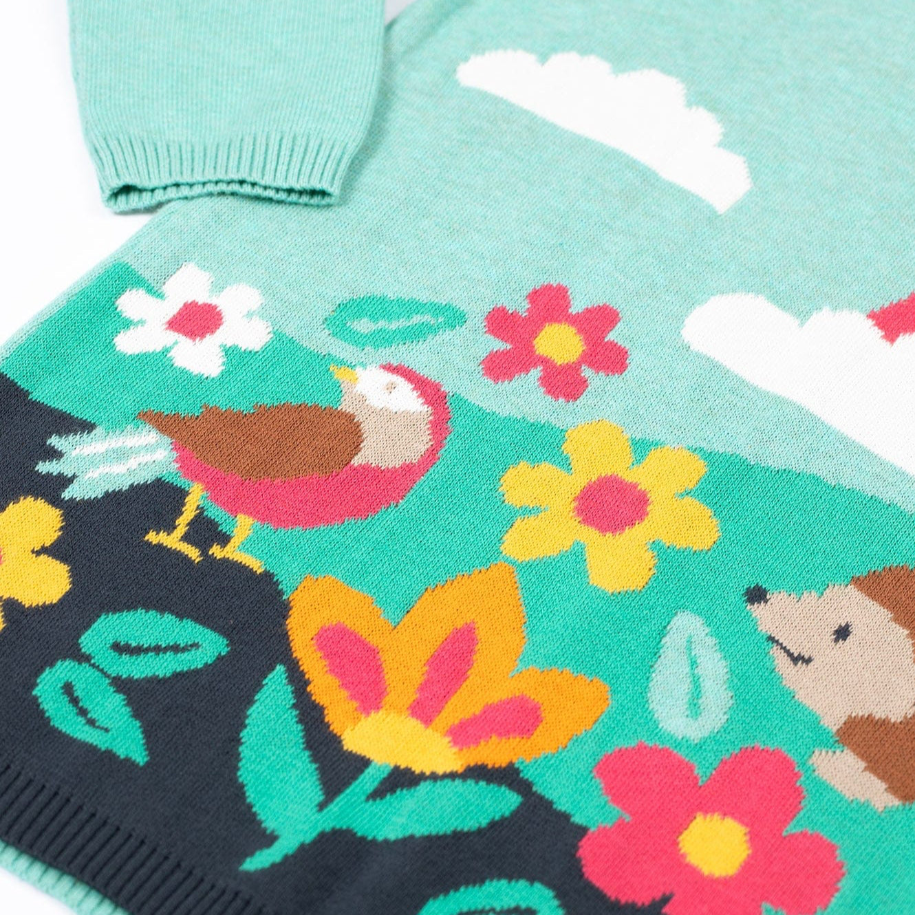 Children's sweater with floral and animal pattern on a white background
