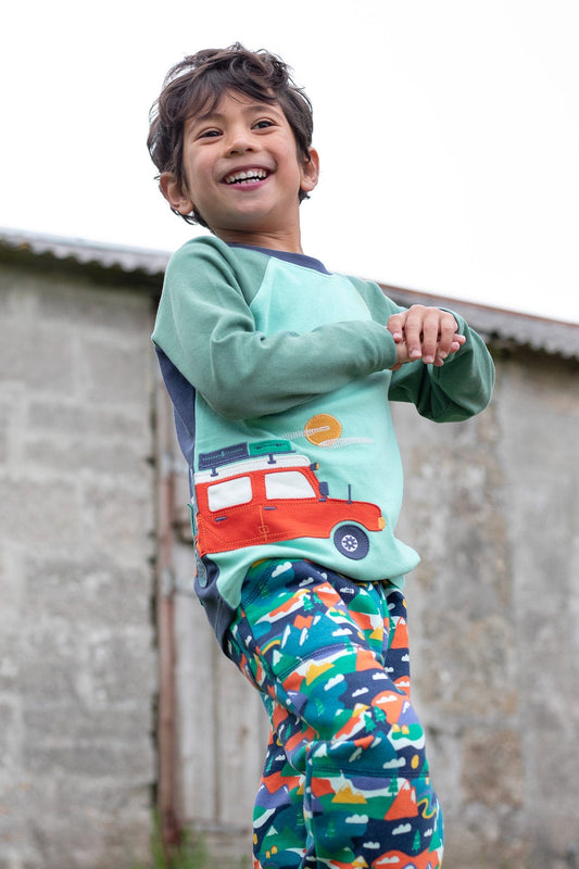 Boy wearing Albert camper long sleeve top and matching Frugi Malpas joggers outside.