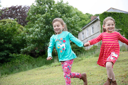 two girls running on the English countryside in their Frugi outfits from AW24.