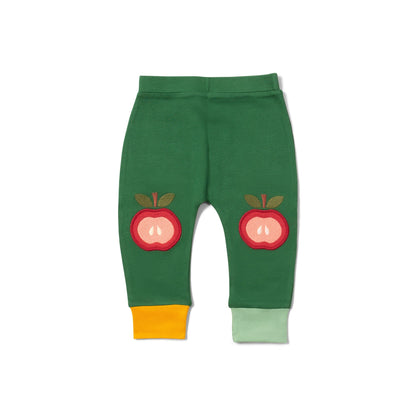Green baby leggings with red apple designs on a white background