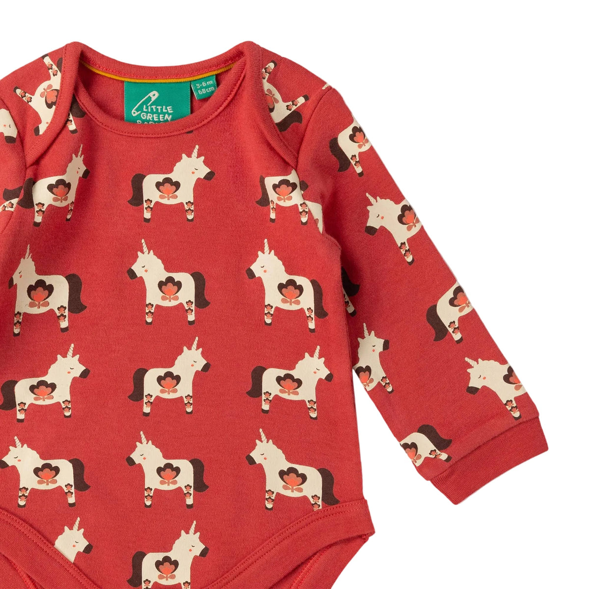 A red long-sleeve baby bodysuit with an all-over print of cowboy horses wearing red cowboy hats. The bodysuit has a green neck label that reads 'A Little Queen'.